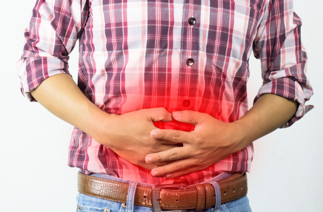 Hombre con estreñimiento llevándose las manos al estómago